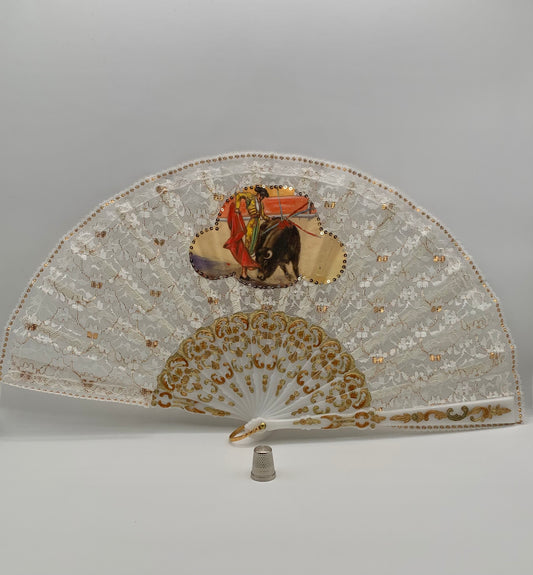 Abanico de pasta color blanco nácar, encaje blanco y dorado con imagen impresa de torero