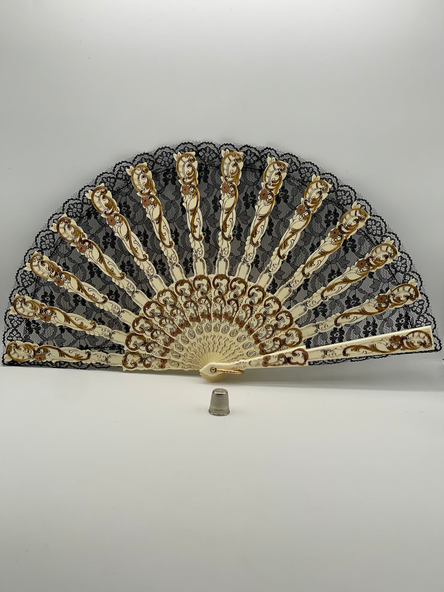 Abanico antiguo de pasta color hueso con adornos en dorado y encaje negro