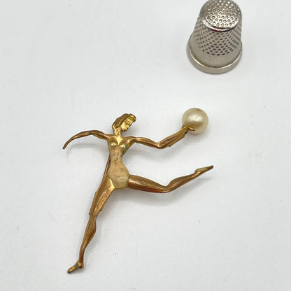 Broche art decó de metal y perla de bisutería, mujer con esfera.