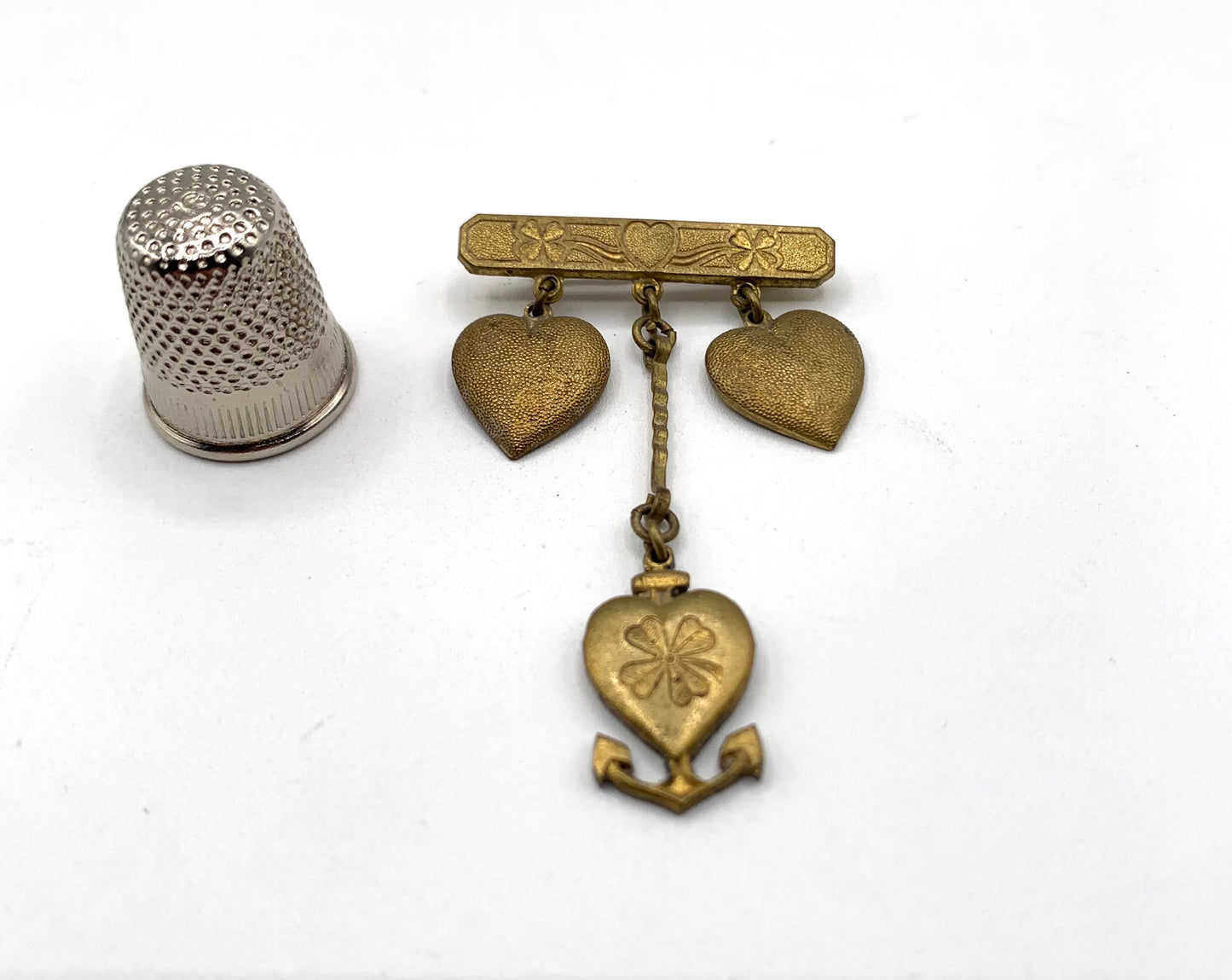 Broche vintage de metal dorado con forma de corazones