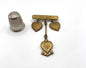 Broche vintage de metal dorado con forma de corazones