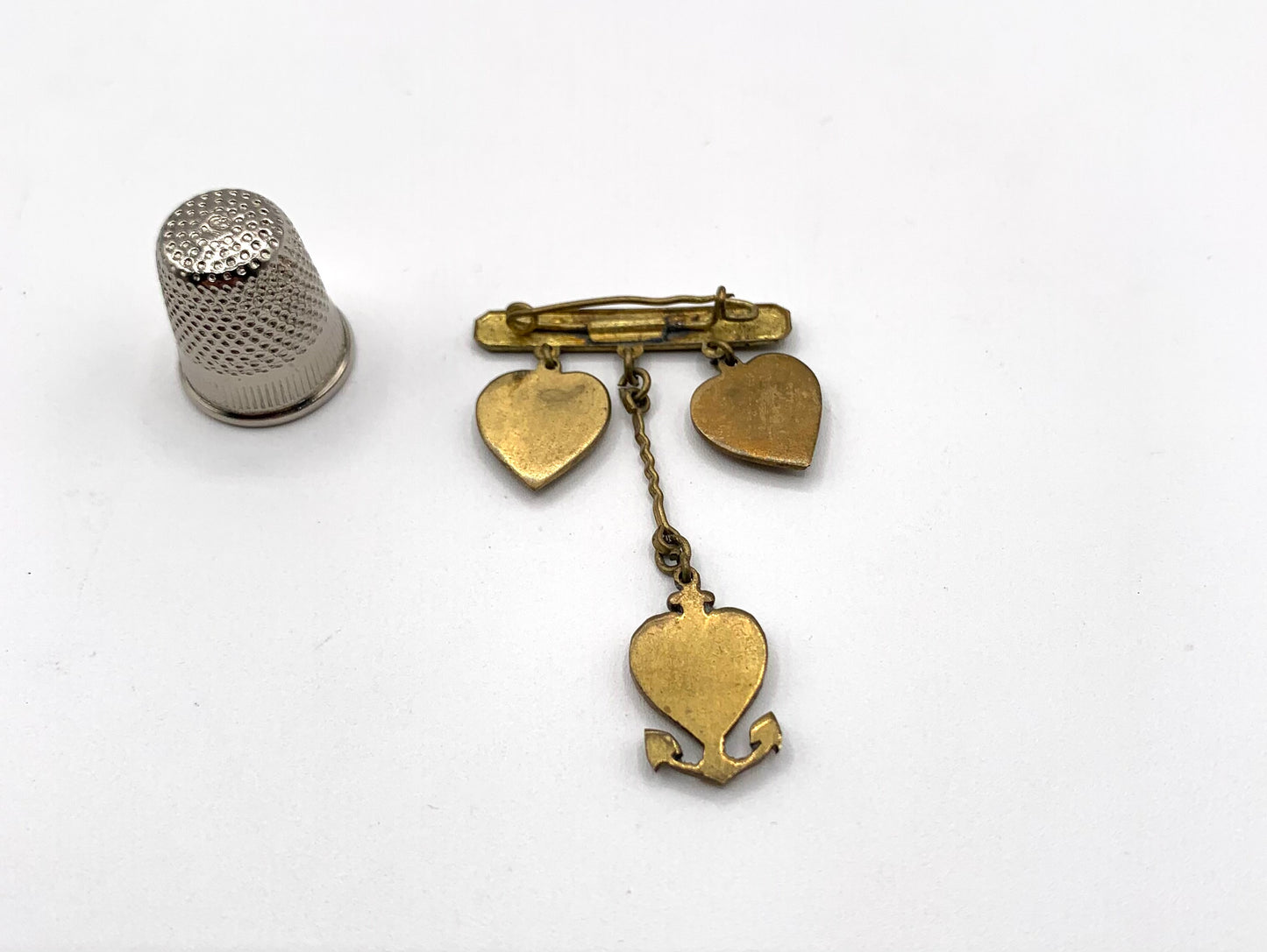 Broche vintage de metal dorado con forma de corazones