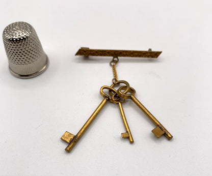 Broche vintage de metal dorado con forma de llaves