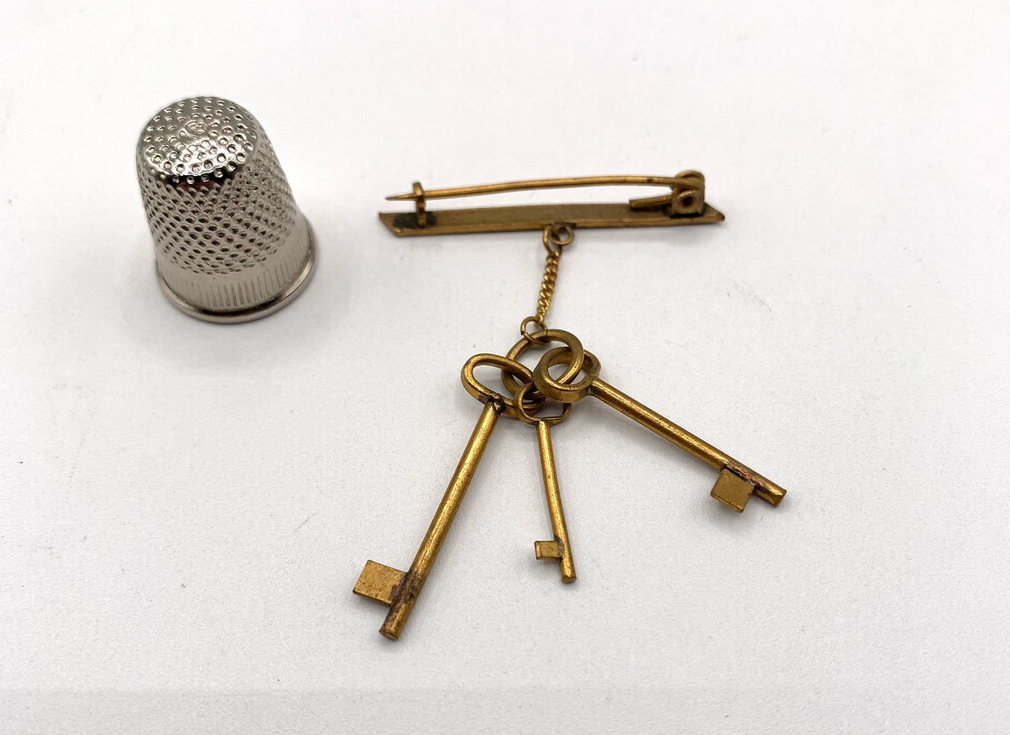 Broche vintage de metal dorado con forma de llaves