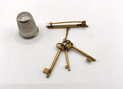 Broche vintage de metal dorado con forma de llaves