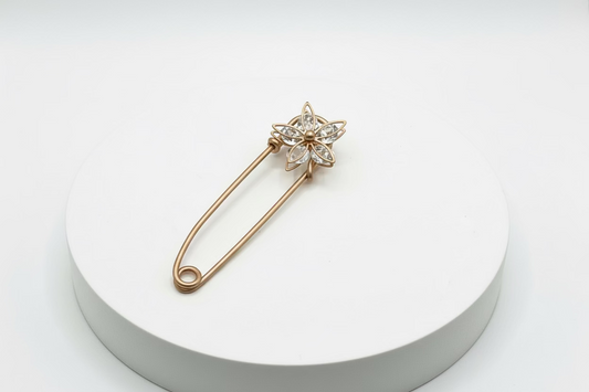 Broche tipo imperdible fantasía con forma de flor y strass