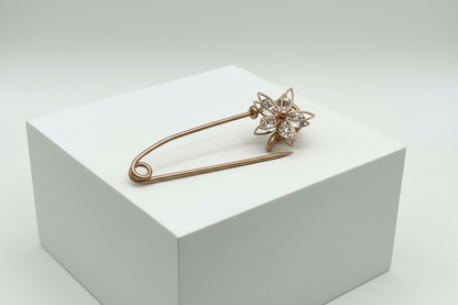 Broche tipo imperdible fantasía con forma de flor y strass