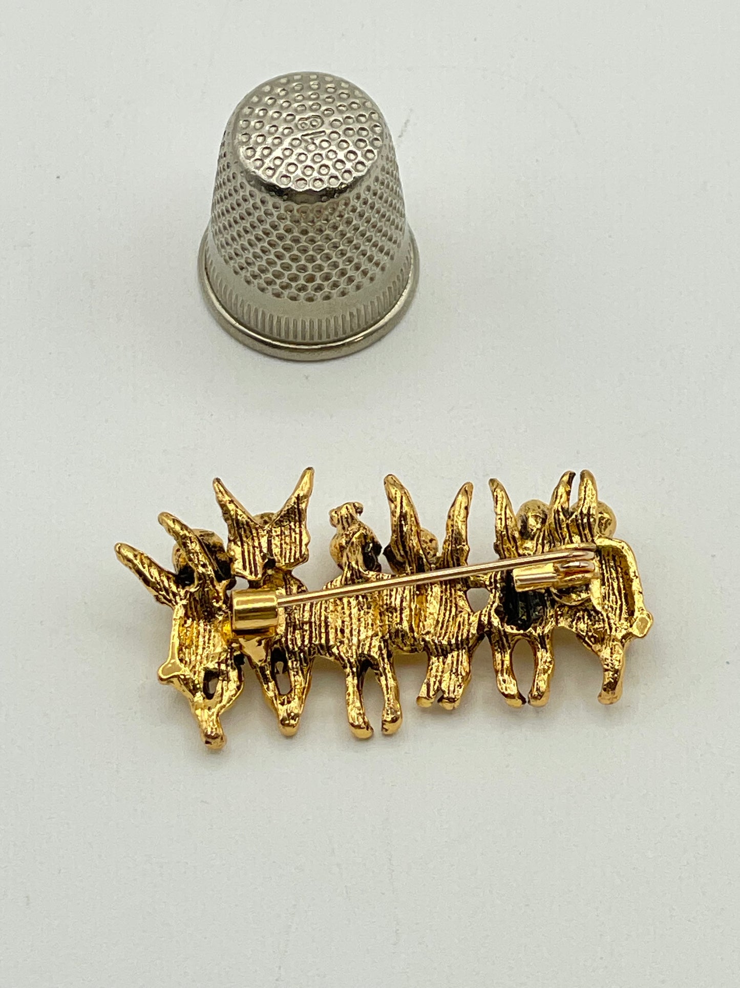 Broche de metal dorado con forma de ángeles
