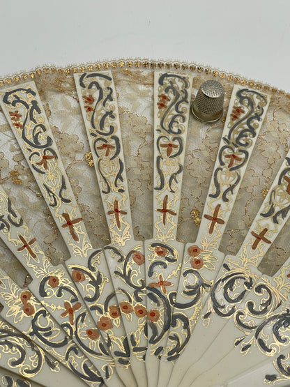 Abanico antiguo de pasta blanco con adornos en dorado y encaje beige y dorado