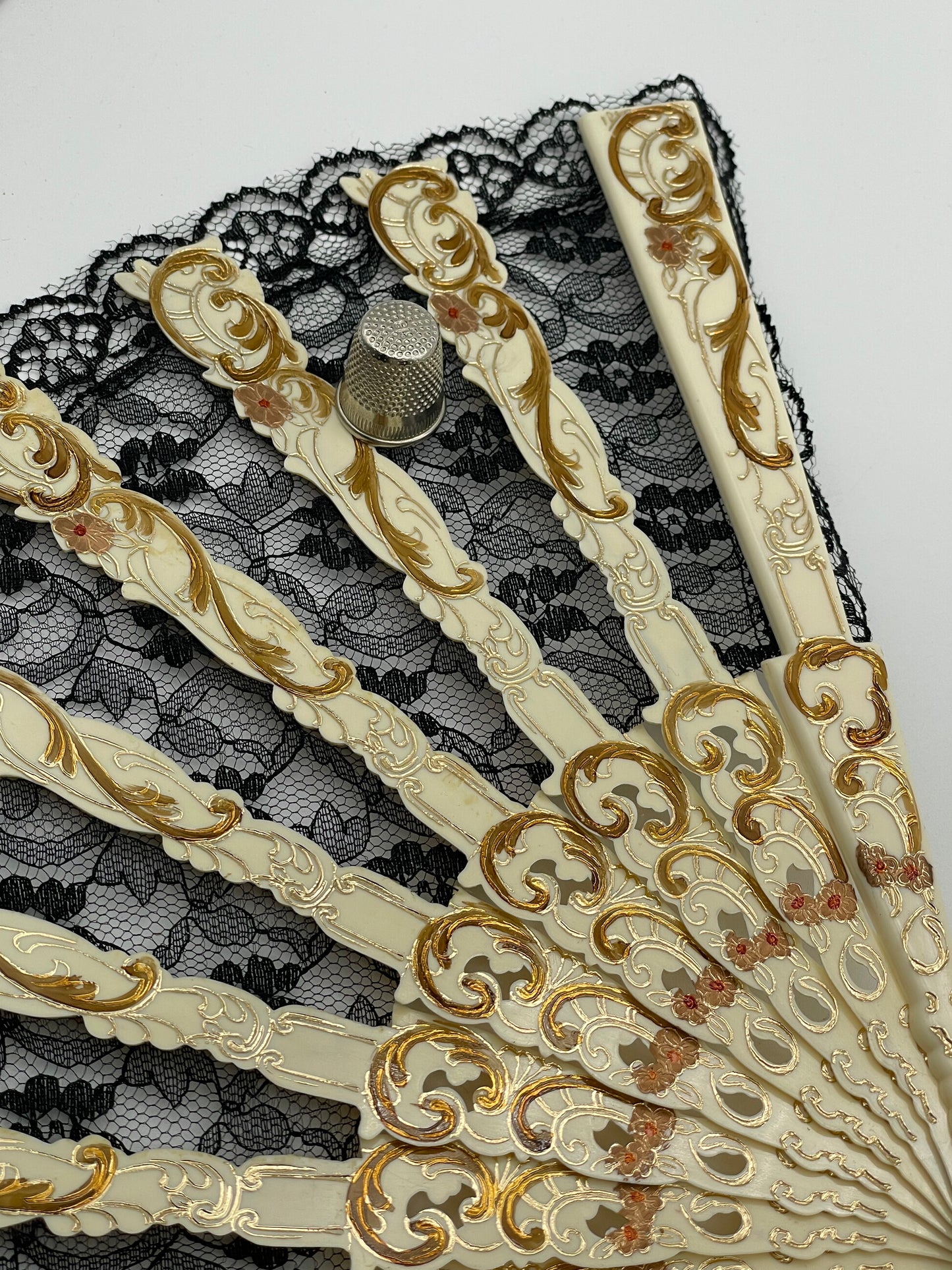 Abanico antiguo de pasta color hueso con adornos en dorado y encaje negro