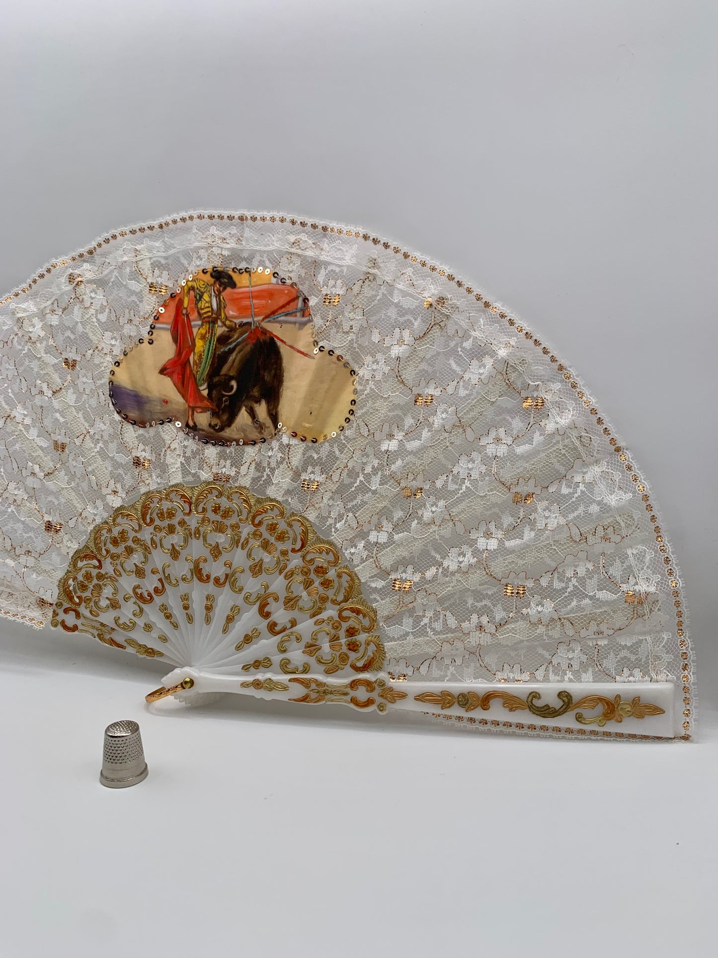 Abanico de pasta color blanco nácar, encaje blanco y dorado con imagen impresa de torero