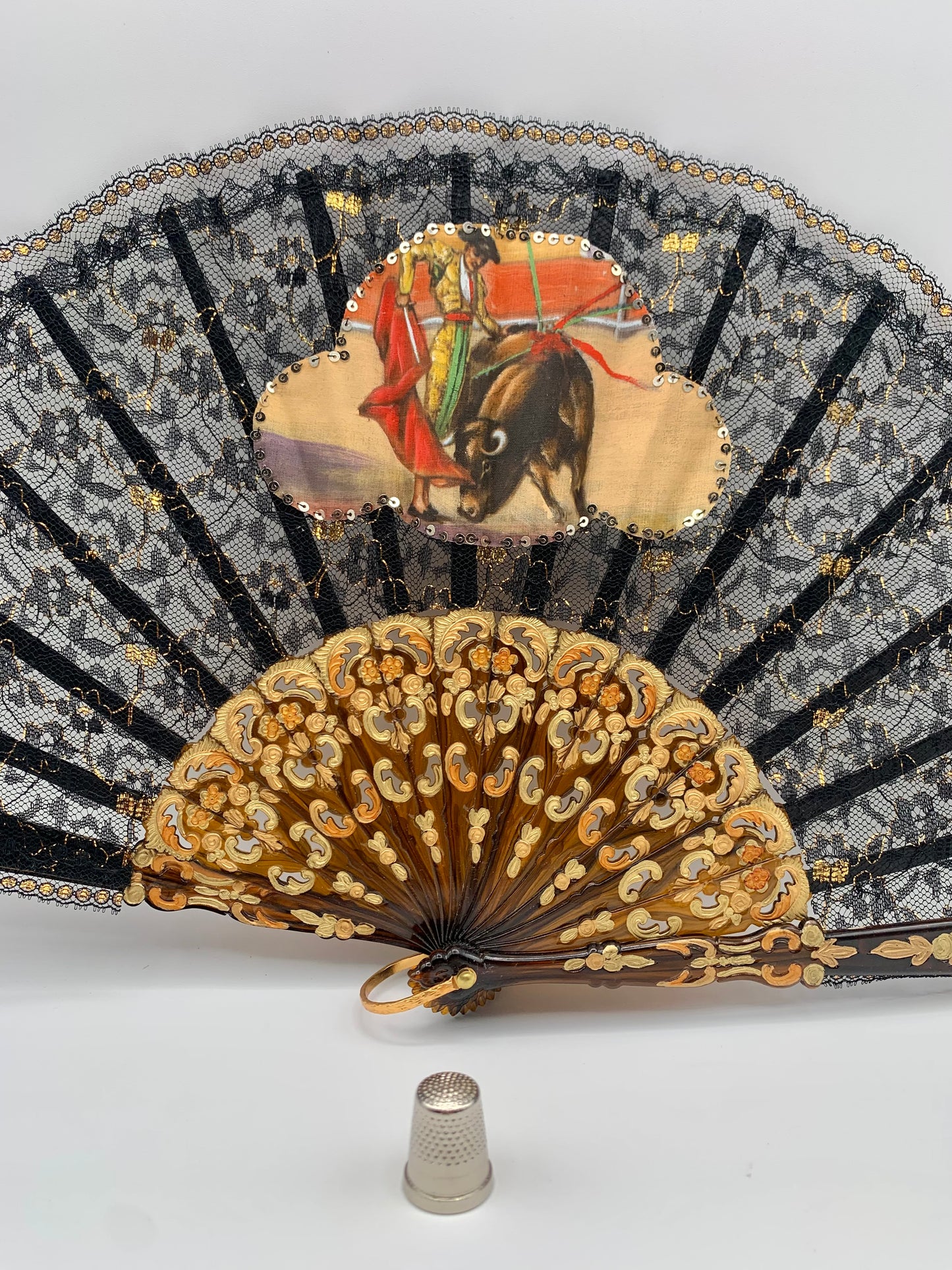 Abanico de pasta color carey, encaje negro y dorado con imagen impresa de torero