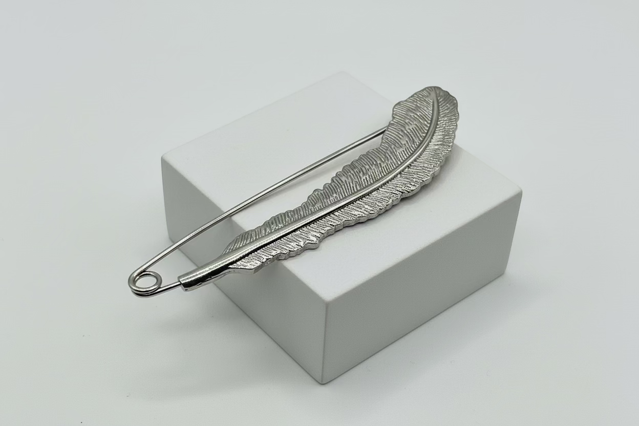 Broche tipo imperdible fantasía con forma de pluma